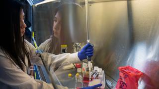 Female latina student working on a Chemistry experiment.